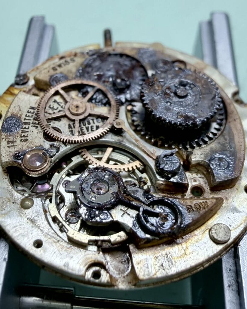Heavily damaged Rolex movement before careful service review.
